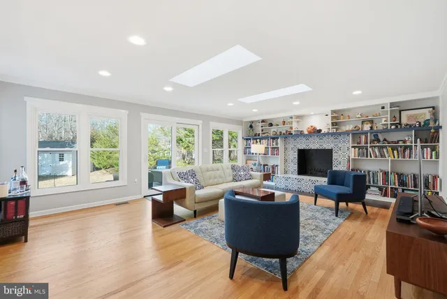 a living room with furniture a flat screen tv and a large window