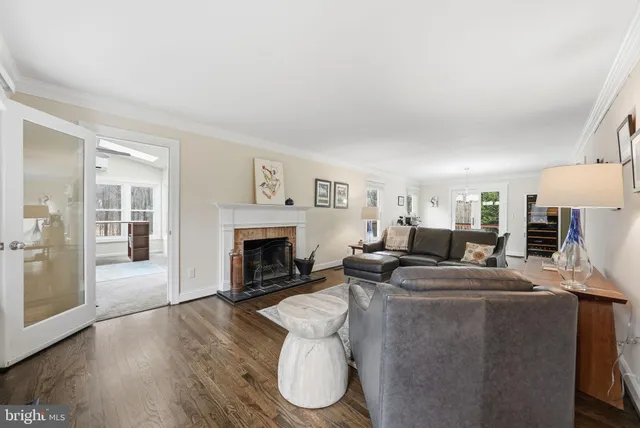 a living room with furniture a fireplace and a floor to ceiling window