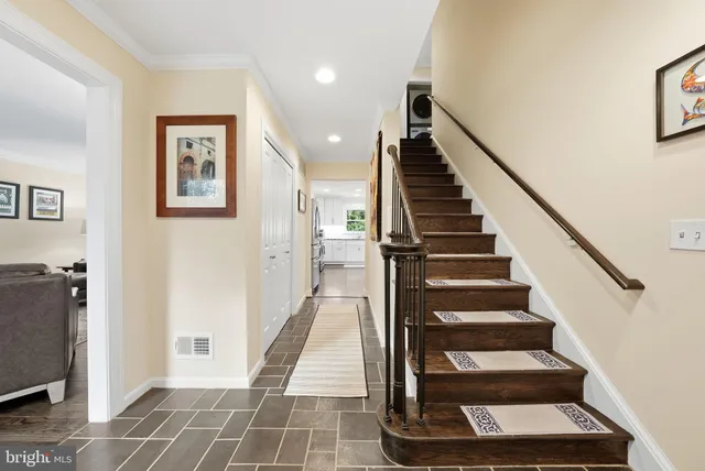 a view of staircase with white walls and a rug