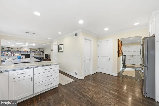a open kitchen with white cabinets and stainless steel appliances