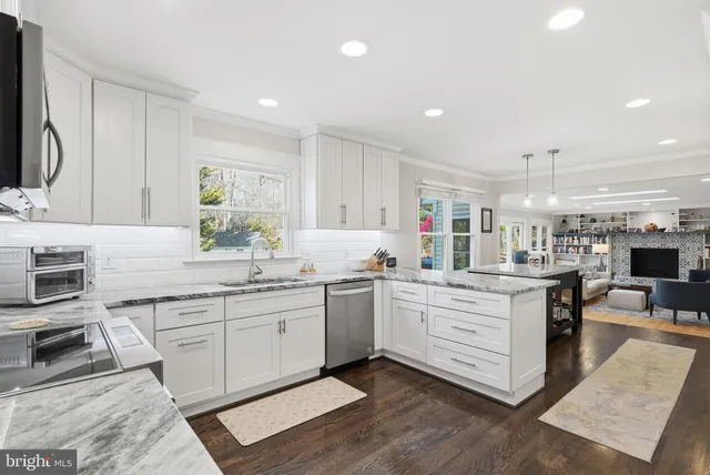 a kitchen with white cabinets and appliances