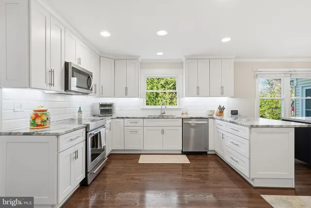 a kitchen with granite countertop cabinets stainless steel appliances a sink and a window