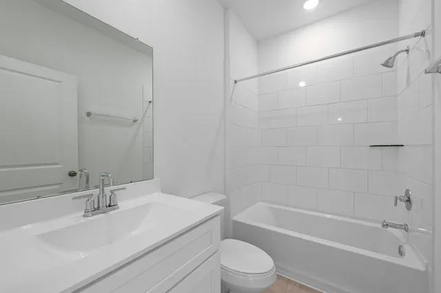 a bathroom with a bathtub shower sink vanity and toilet