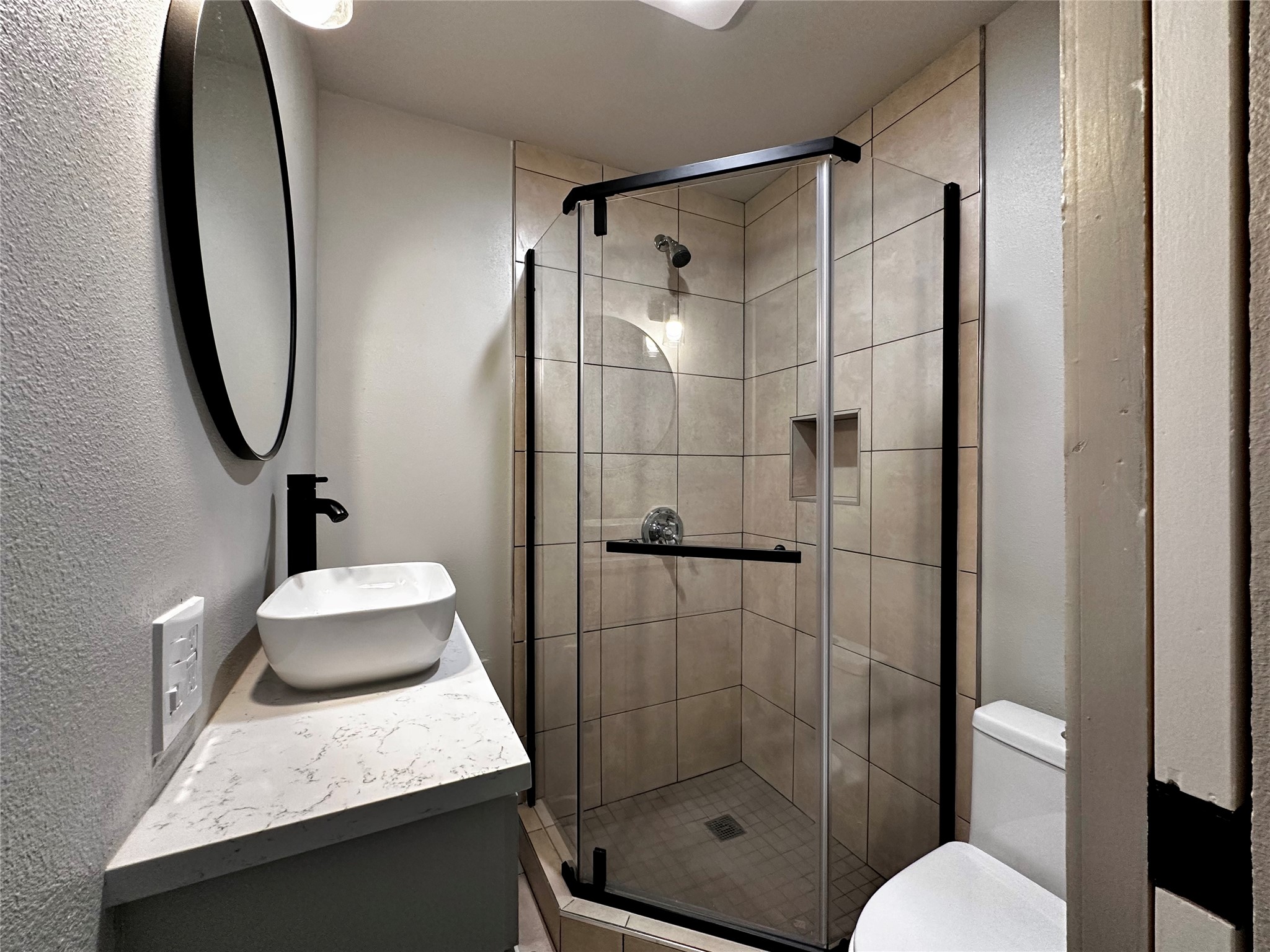 914 East 39th Street, Unit 2 Austin, TX 78751 - Photo 25 of 34 Bathroom with a textured wall, a stall shower, and vanity