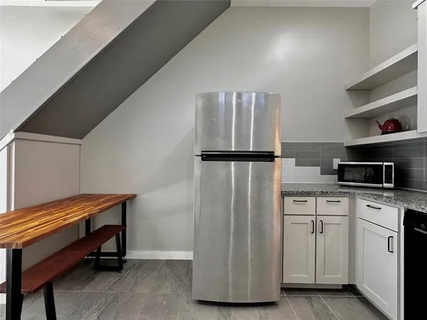a kitchen with white cabinets and white appliances