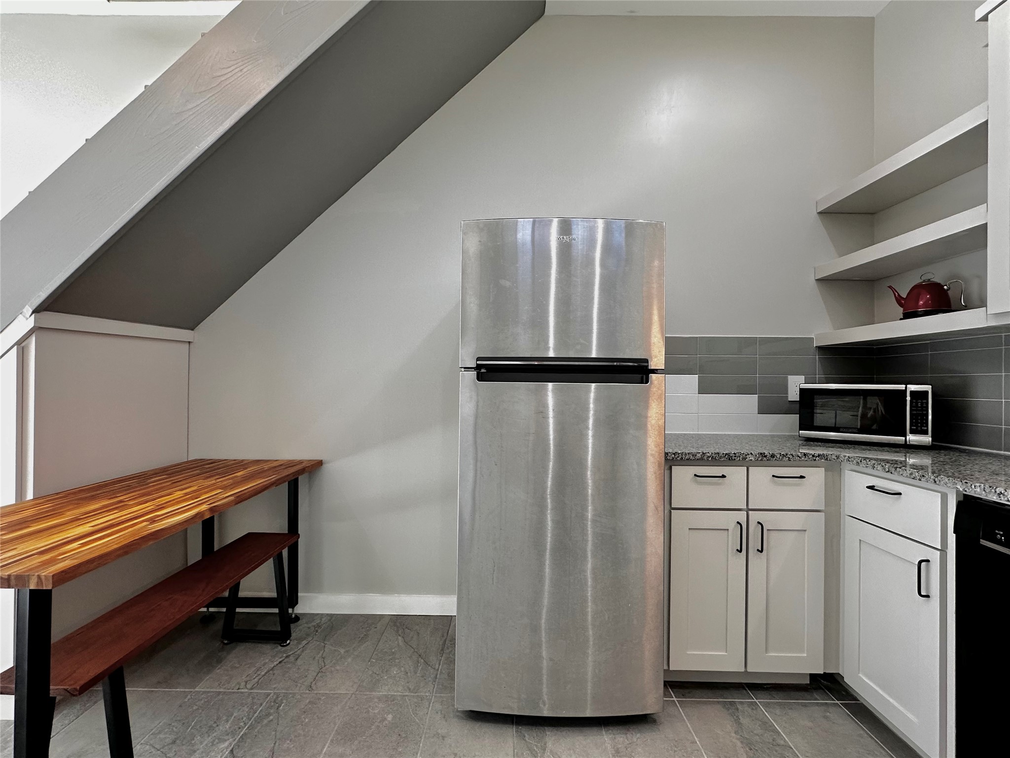 914 East 39th Street, Unit 2 Austin, TX 78751 - Photo 8 of 34 Kitchen featuring light stone counters, stainless steel appliances, open shelves, white cabinetry, and backsplash