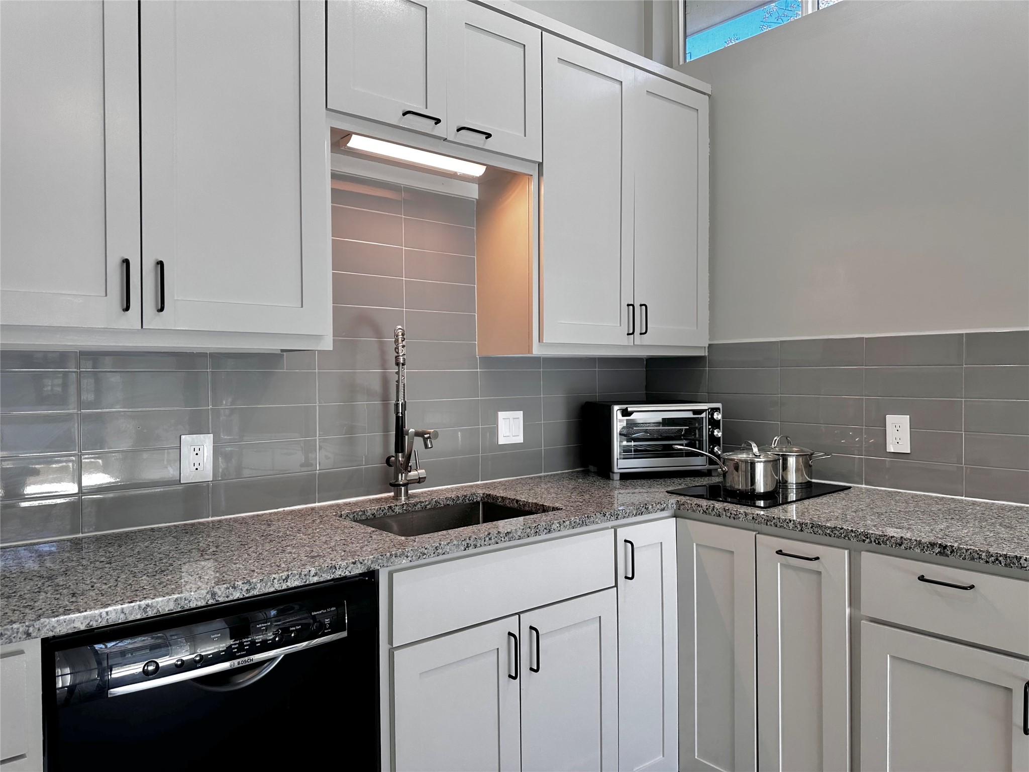 914 East 39th Street, Unit 2 Austin, TX 78751 - Photo 10 of 34 Kitchen featuring black dishwasher, light stone counters, and white cabinets