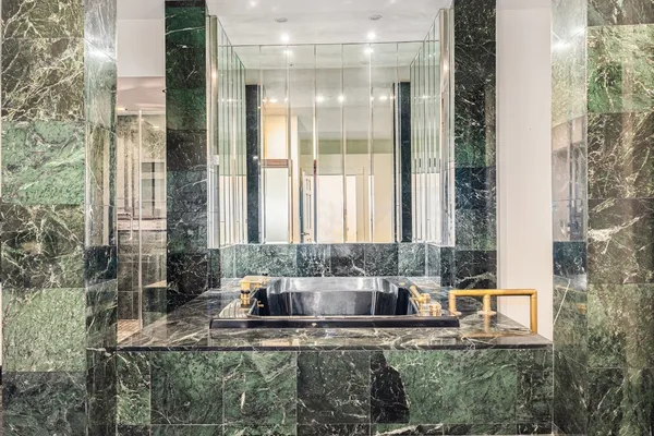 a view of an empty room with wooden floor and a ceiling fan