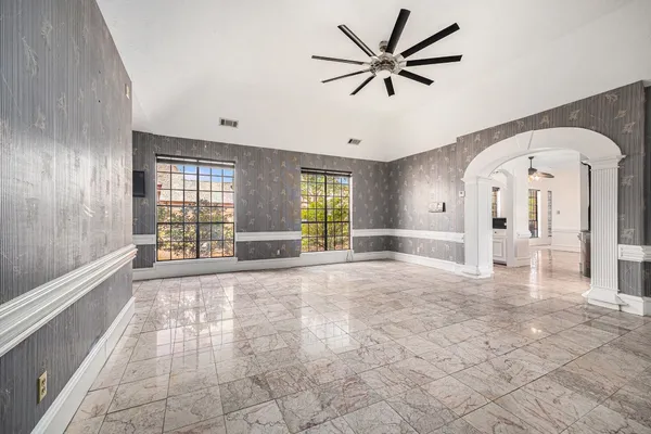 a view of an empty room with window and wooden floor