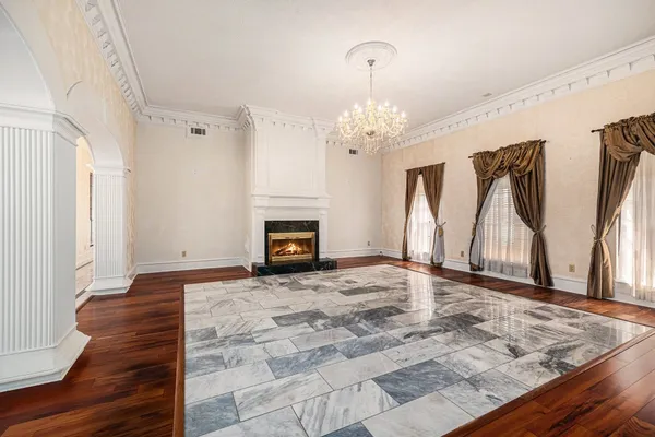 a view of an empty room with a window and a kitchen