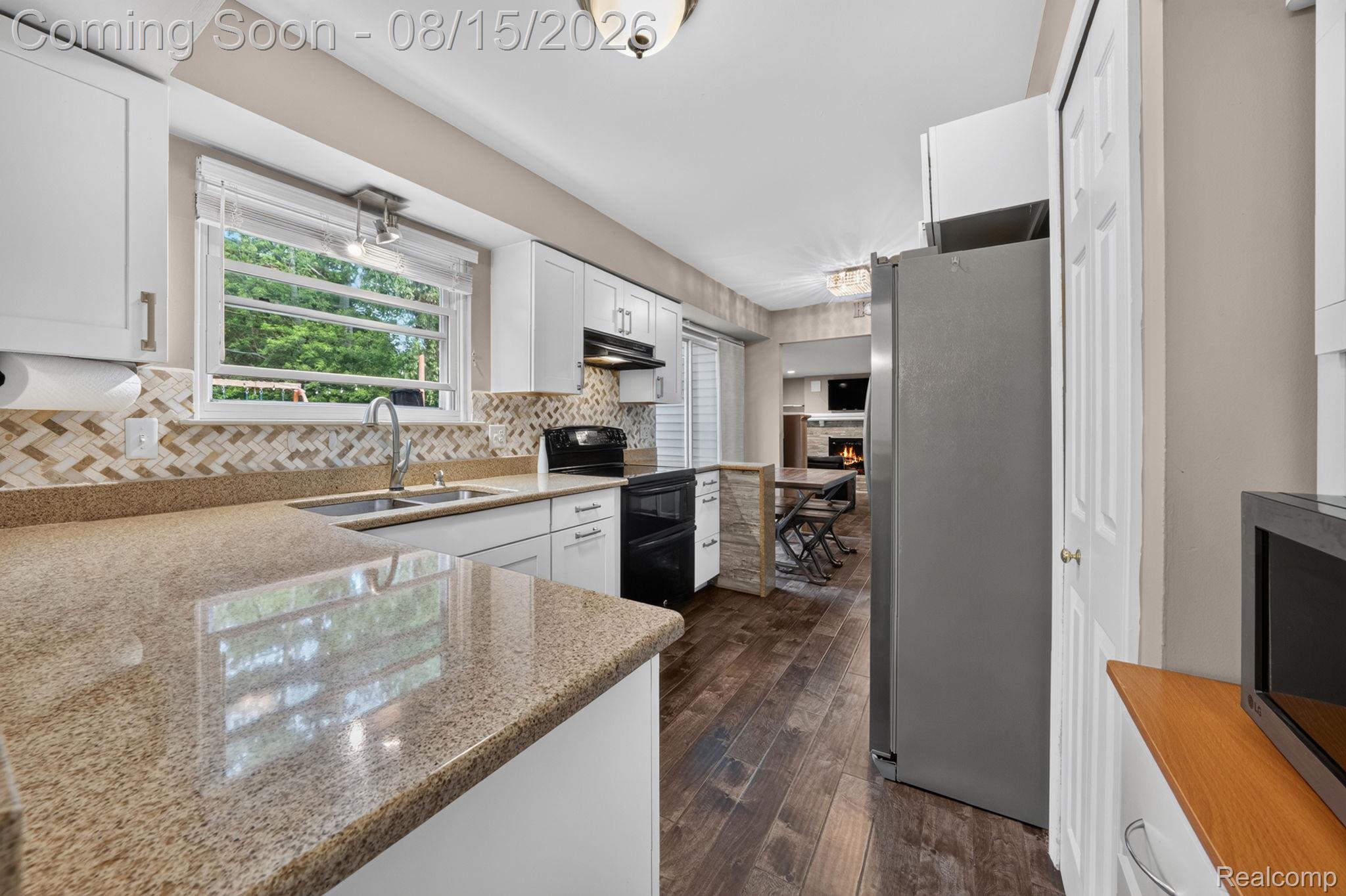 385 Arlington Drive Rochester, MI 48307 - Photo 23 of 47 Kitchen featuring light-toned cabinetry, a stainless steel sink, a mosaic tile backsplash, and stone-finish countertops