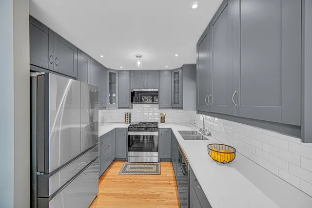 a kitchen with stainless steel appliances granite countertop a refrigerator and a stove