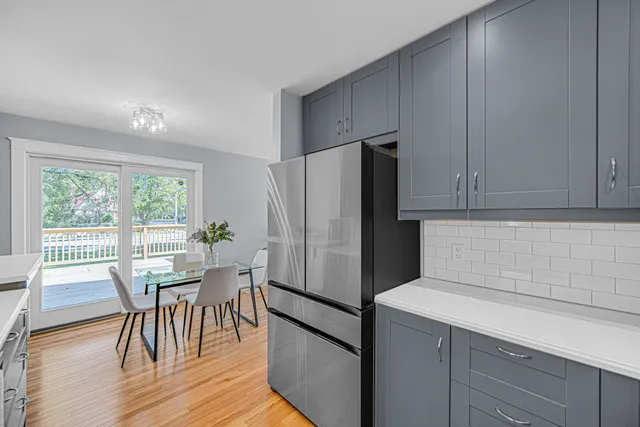 a kitchen with stainless steel appliances a refrigerator a table and chairs