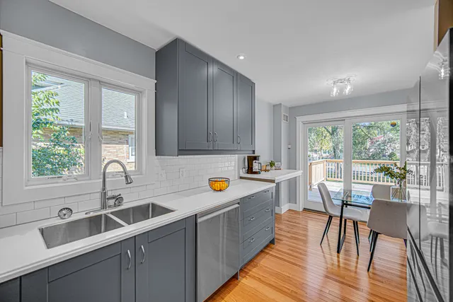 a kitchen with stainless steel appliances granite countertop sink window dining table and chairs
