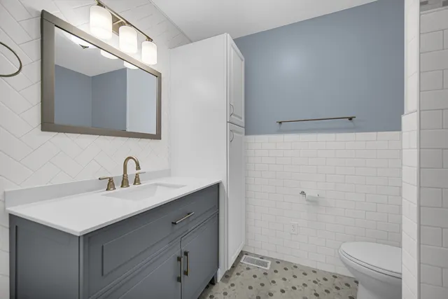 a bathroom with a sink a toilet and shower