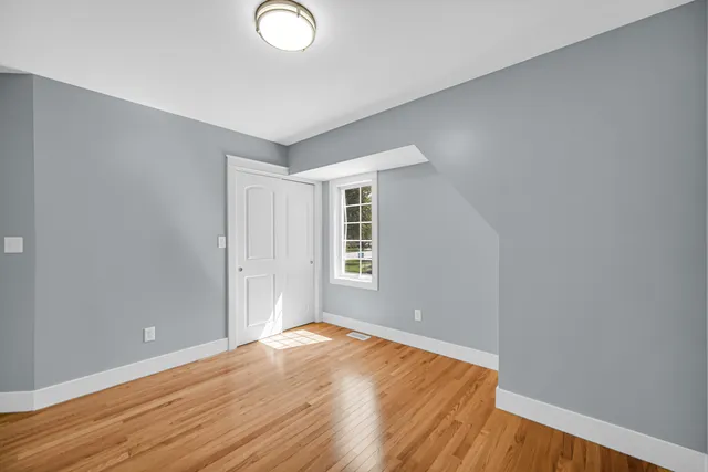 a view of a livingroom with wooden floor and window