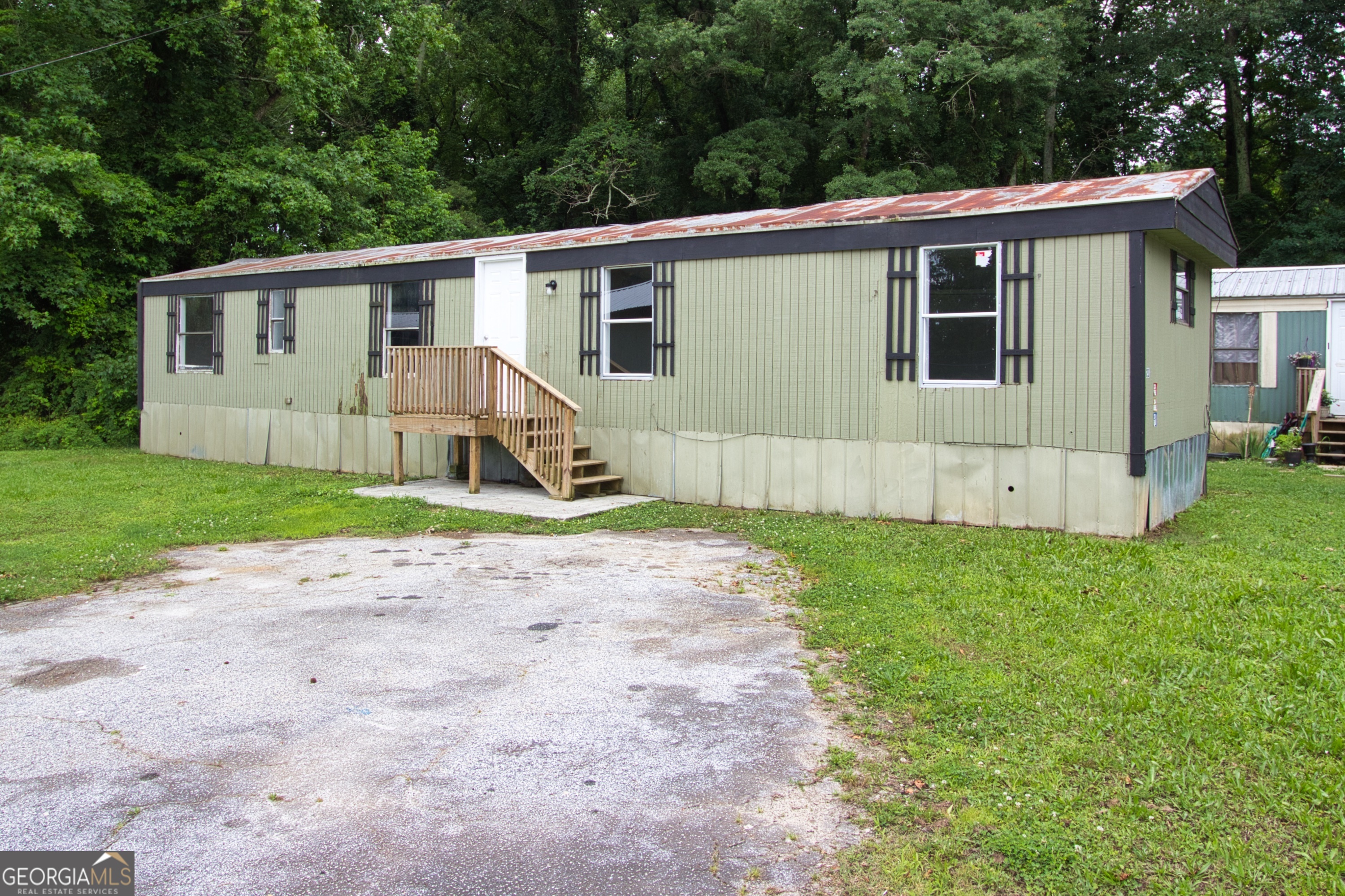 a view of a house with a yard and large tree