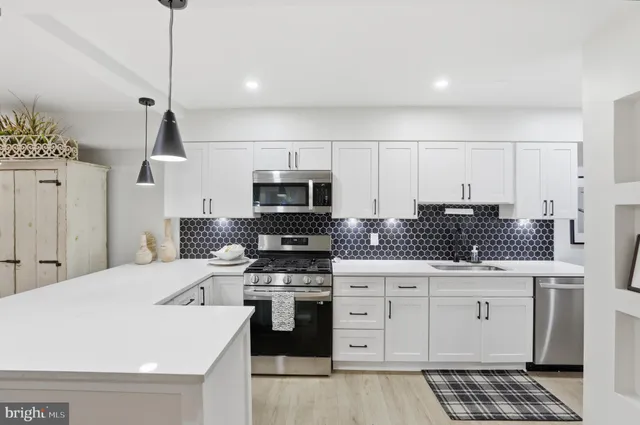 a kitchen with white cabinets and appliances