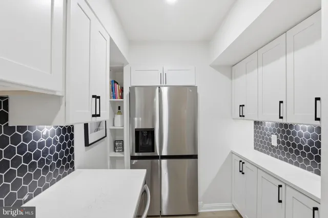 a kitchen with granite countertop a refrigerator and a sink
