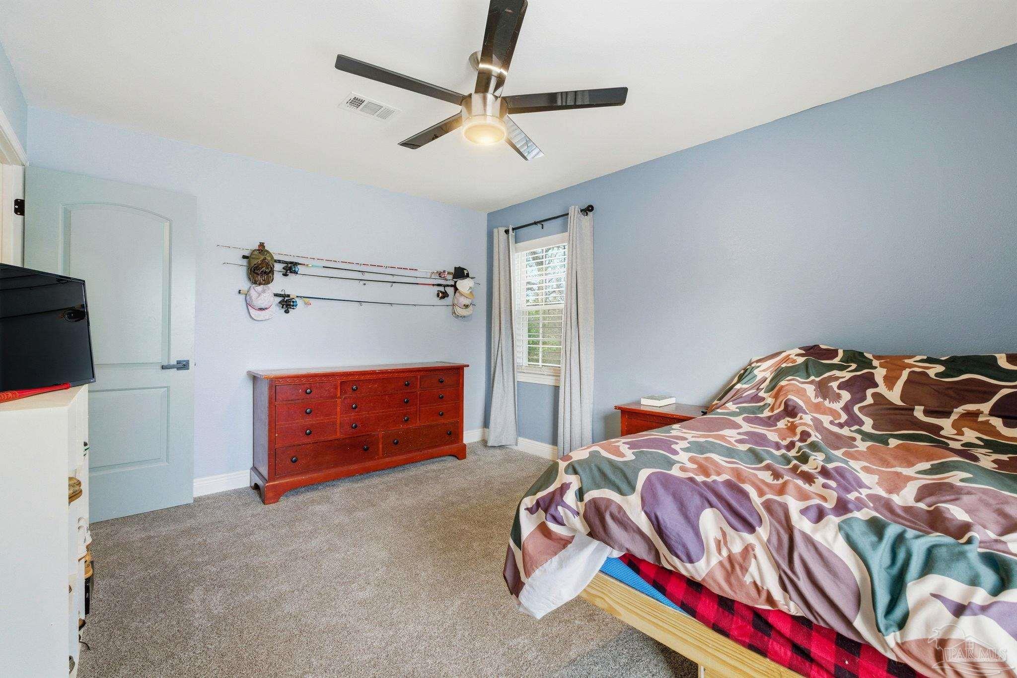 690 Cooley Road Cantonment, FL 32533 - Photo 38 of 64 a bedroom with a bed and a chandelier