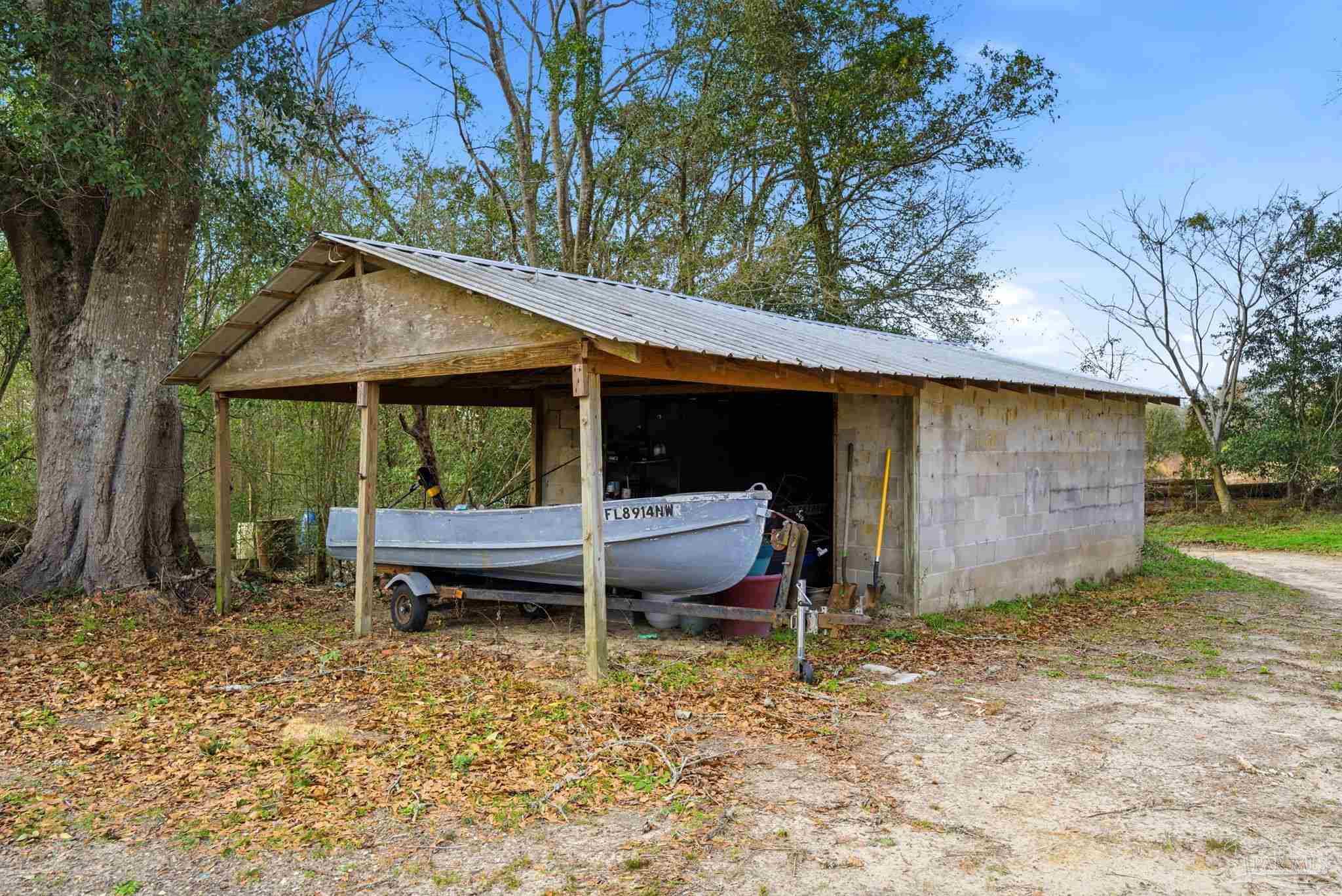 690 Cooley Road Cantonment, FL 32533 - Photo 51 of 64 a backyard of a house with barbeque oven table and chairs