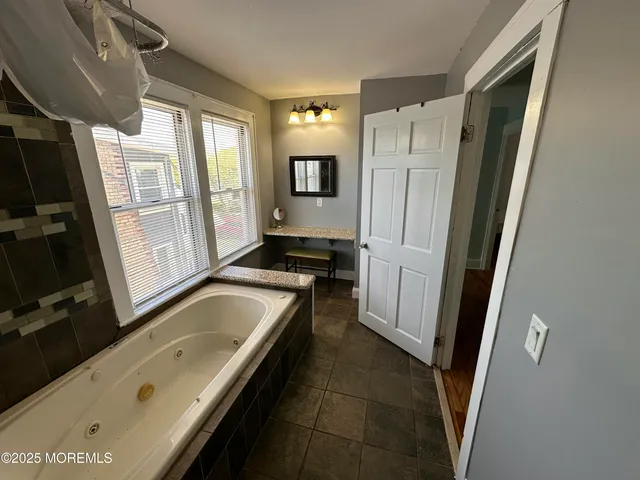 a bathroom with a tub sink and mirror