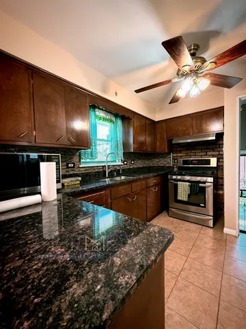 a kitchen with stainless steel appliances granite countertop a sink and a stove