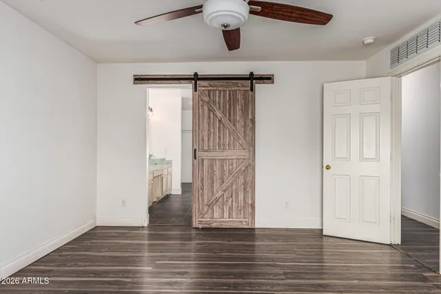 a view of a white house with a yard potted plants and a large tree