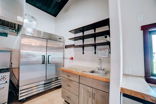 a kitchen with kitchen island granite countertop a stove a refrigerator and a cabinets