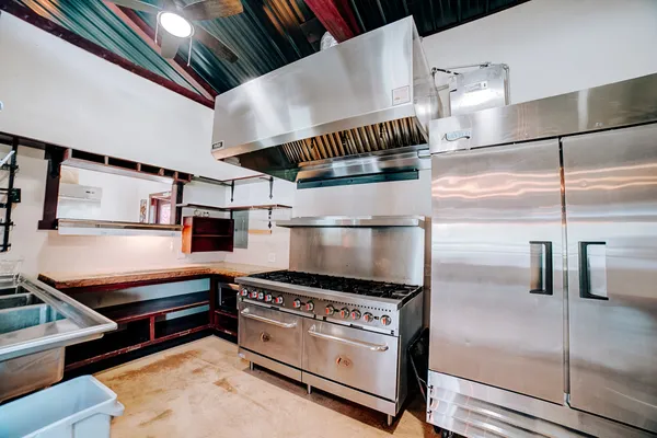 a kitchen with stainless steel appliances granite countertop a stove and cabinets