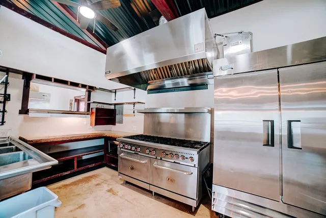 a kitchen with stainless steel appliances granite countertop a stove and cabinets