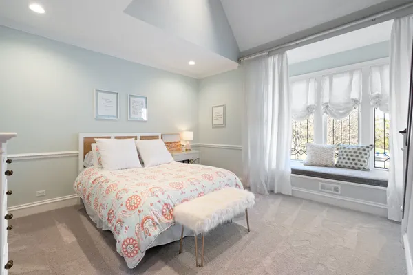 a spacious bedroom with a bed and a chandelier