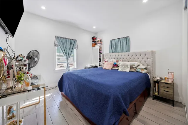 a bedroom with a bed a dresser and potted plants