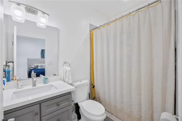 a bathroom with a sink a toilet and shower curtain