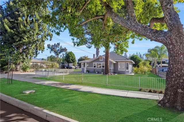 a view of a big house with a big yard and large trees