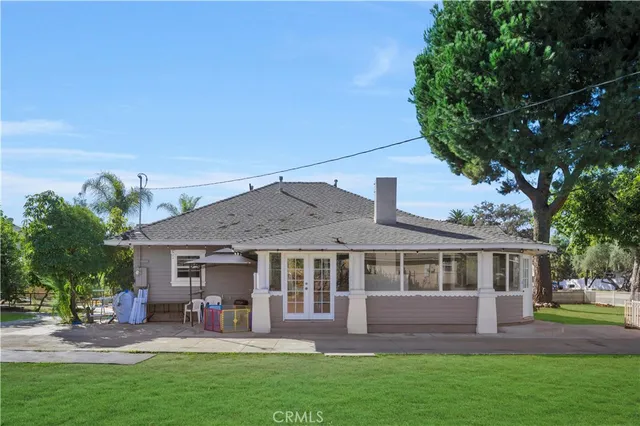 a view of a house with a yard and large tree