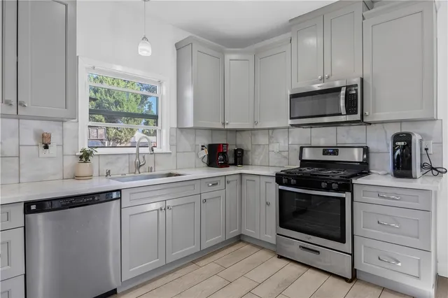 a kitchen with stainless steel appliances granite countertop a stove a sink and a microwave