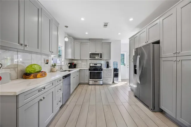 a kitchen with stainless steel appliances a refrigerator sink and cabinets