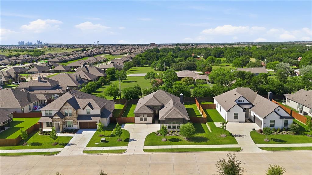 4017 Alpine Street Midlothian, TX 76065 - Photo 36 of 37 Residential street featuring three distinct homes with attached garages, concrete driveways, and manicured lawns