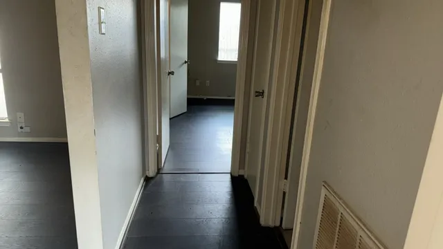 a view of a hallway with wooden floor and staircase