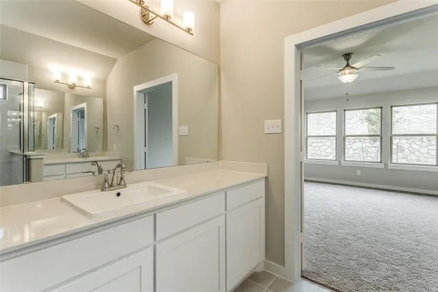 a en suite bathroom with a sink double vanity and a large mirror