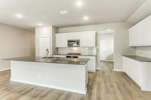 a kitchen with stainless steel appliances a sink stove and cabinets