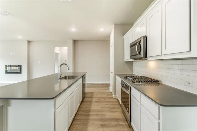 a kitchen with stainless steel appliances granite countertop a sink and a stove