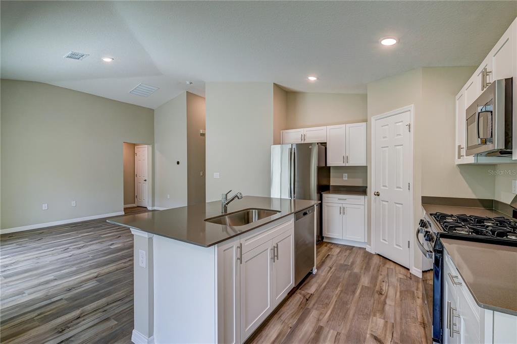 12730 Hysmith Loop Parrish, FL 34219 - Photo 11 of 33 a kitchen with kitchen island granite countertop a sink and refrigerator
