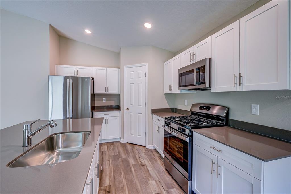 12730 Hysmith Loop Parrish, FL 34219 - Photo 6 of 33 a kitchen with a sink stove and refrigerator