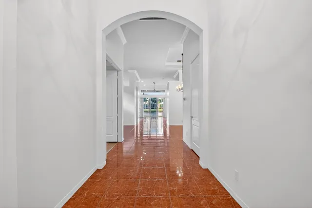 a kitchen with stainless steel appliances granite countertop a refrigerator a sink dishwasher and white cabinets with wooden floor