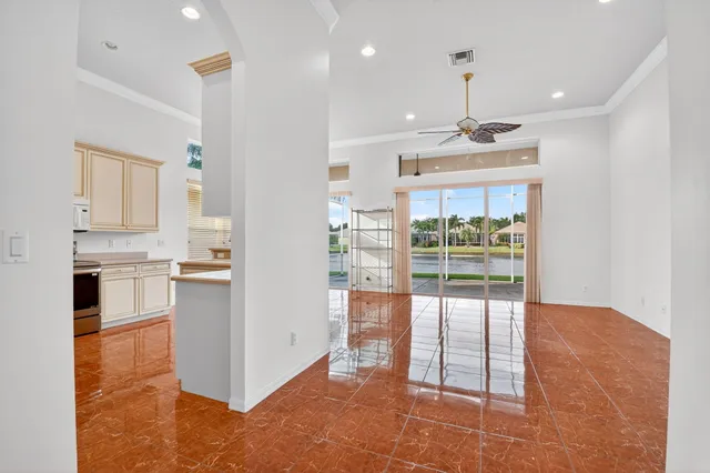 a view of empty room with wooden floor and ceiling fan