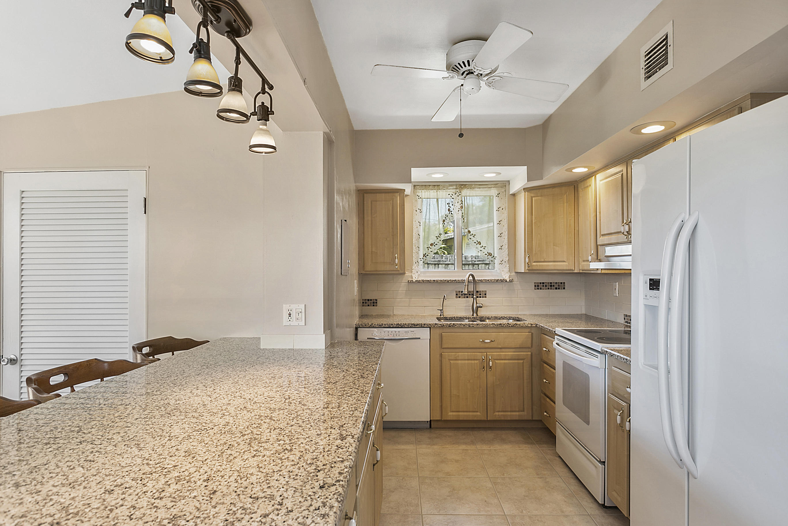 353 Shady Lane Road Palm Springs, FL 33461 - Photo 17 of 30 a kitchen with a sink stove and refrigerator