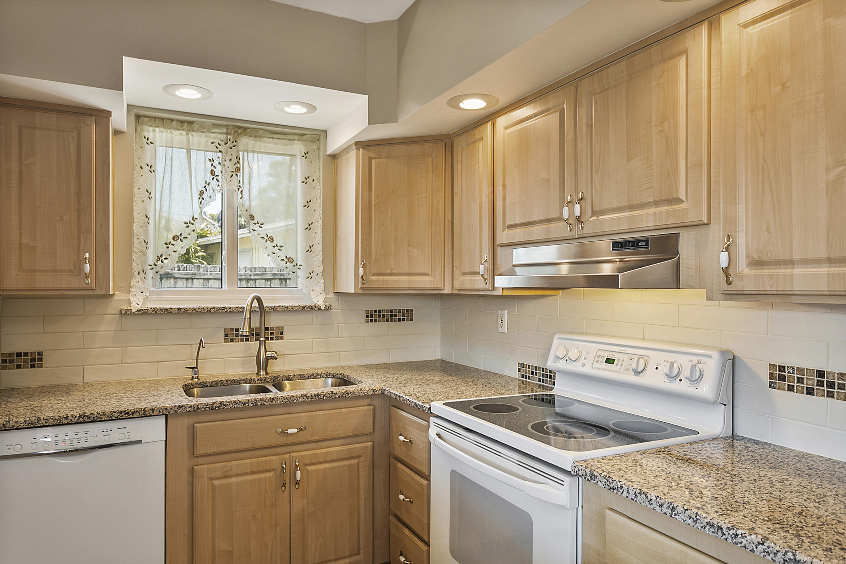 353 Shady Lane Road Palm Springs, FL 33461 - Photo 18 of 30 a kitchen with stainless steel appliances granite countertop a sink stove and cabinets