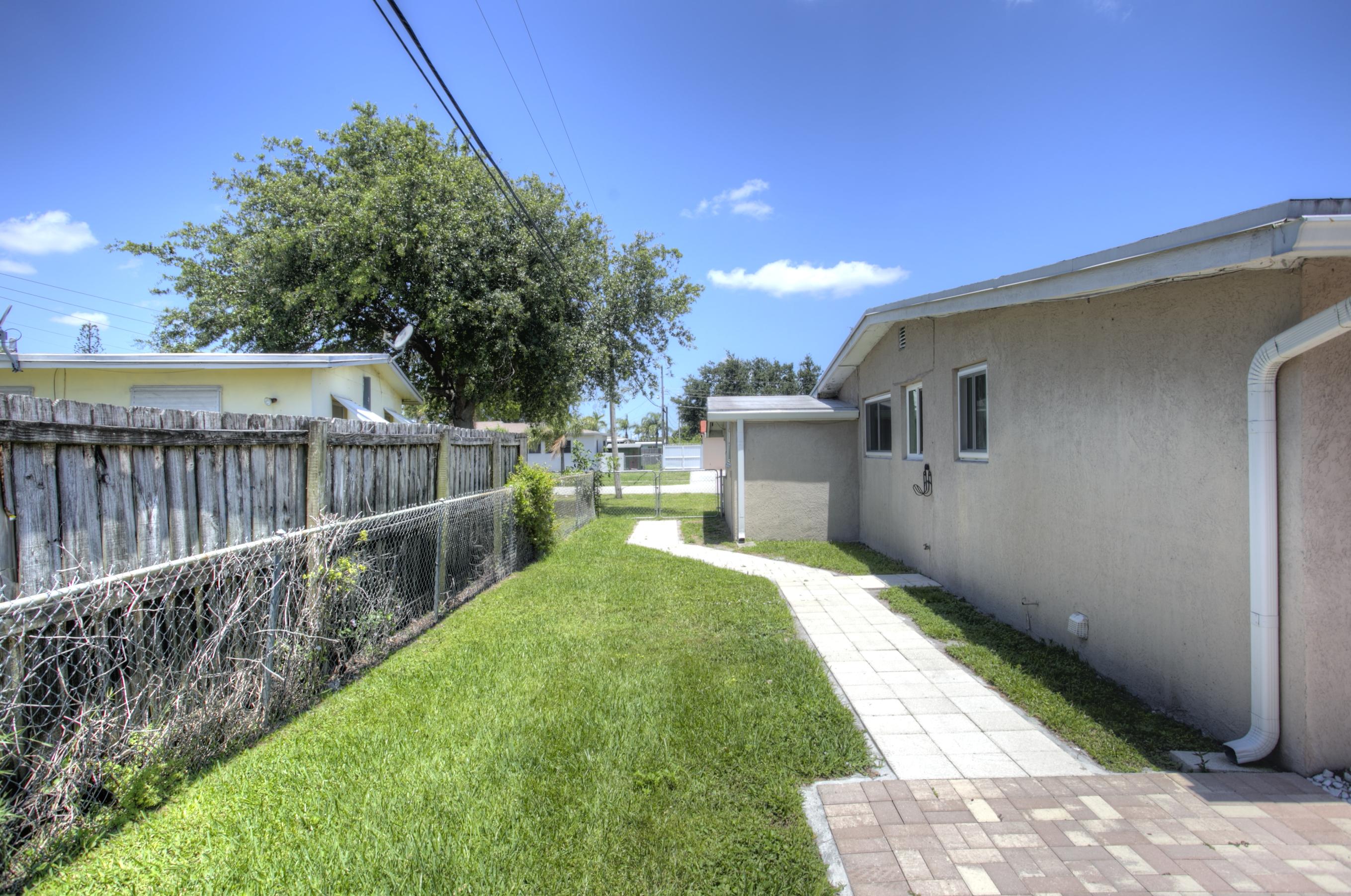 353 Shady Lane Road Palm Springs, FL 33461 - Photo 20 of 30 a view of a backyard with wooden fence